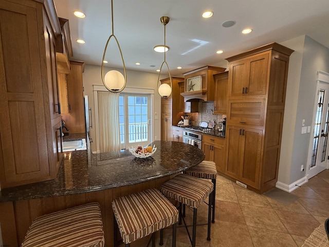 kitchen with brown cabinets, tasteful backsplash, recessed lighting, a peninsula, and stainless steel oven