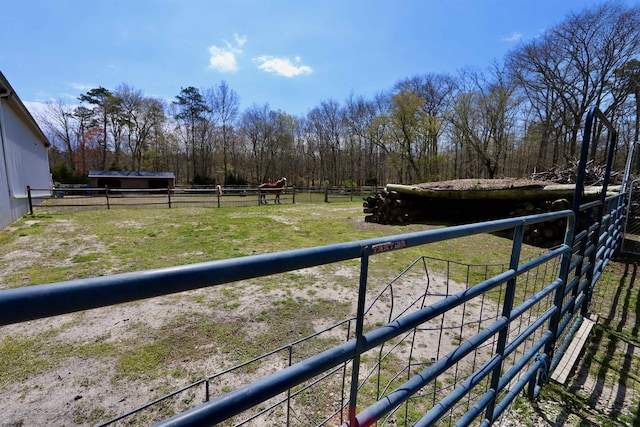 view of yard with an outbuilding, a rural view, and an exterior structure