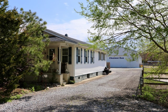 view of front facade featuring a garage, an outdoor structure, and fence