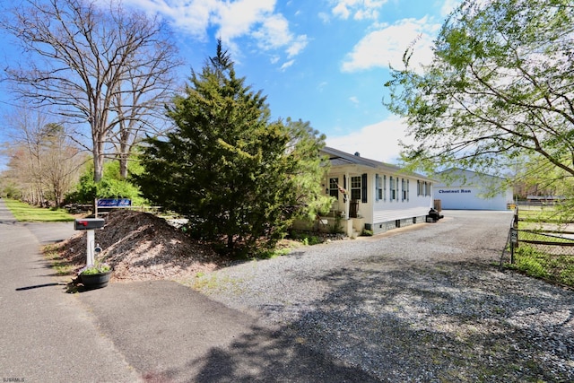 view of side of home featuring an outdoor structure and driveway