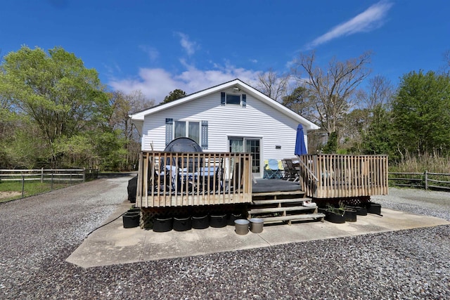 rear view of house with a deck and fence