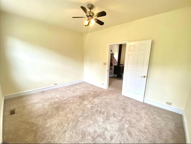 carpeted empty room featuring visible vents, baseboards, and a ceiling fan