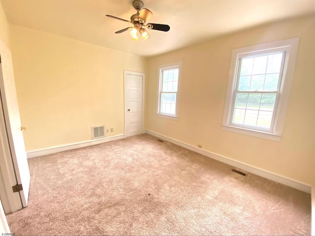 spare room with visible vents, carpet floors, and baseboards