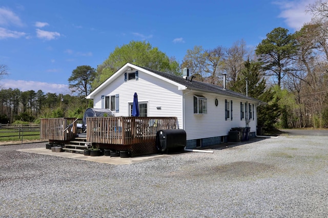 view of front facade featuring a wooden deck and fence