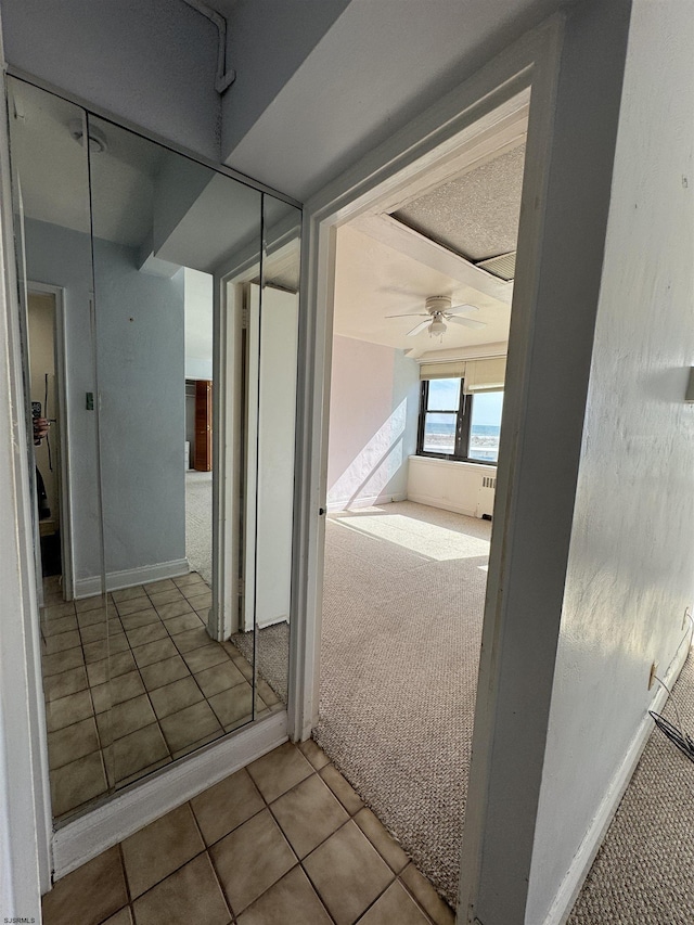 hallway with tile patterned flooring and carpet flooring