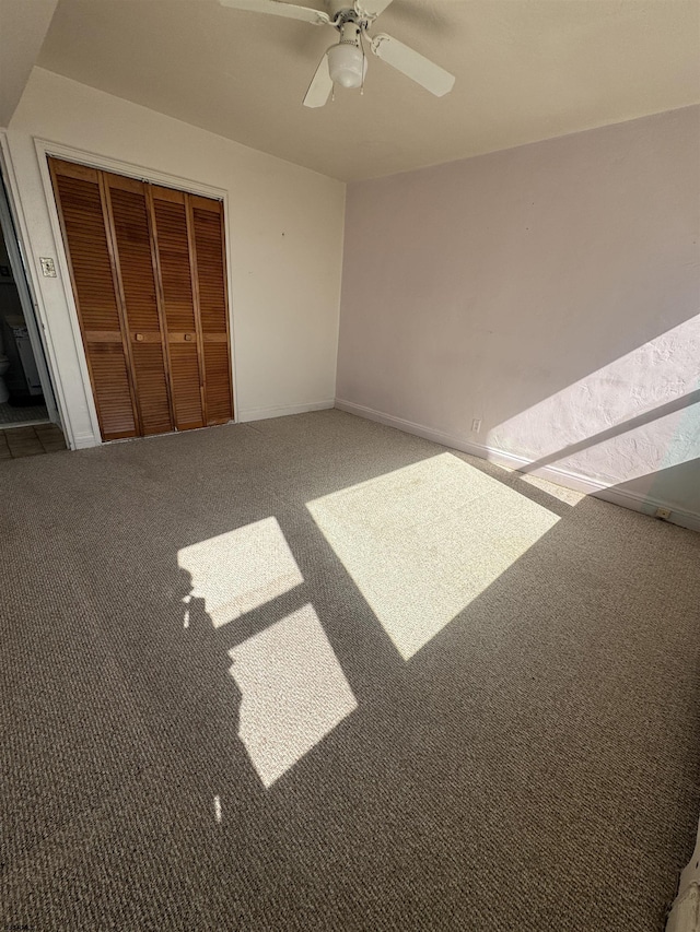 unfurnished bedroom with a ceiling fan, carpet, and a closet