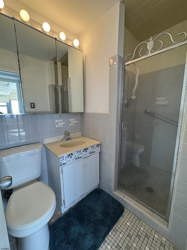 full bath with toilet, tile walls, a stall shower, and vanity