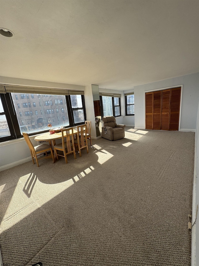 unfurnished dining area featuring baseboards and carpet floors