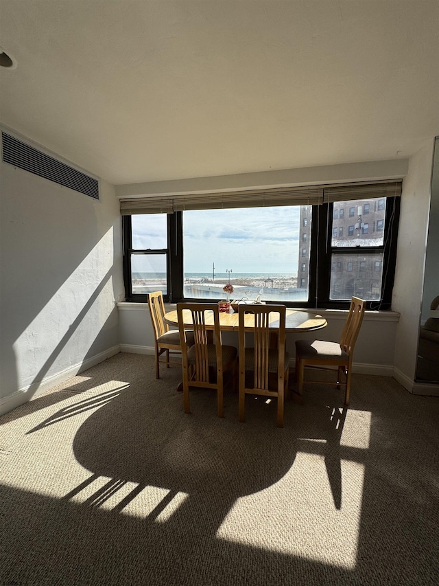 carpeted dining area featuring visible vents and baseboards