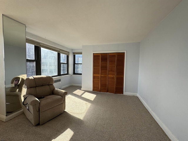 sitting room with carpet flooring, radiator heating unit, and baseboards