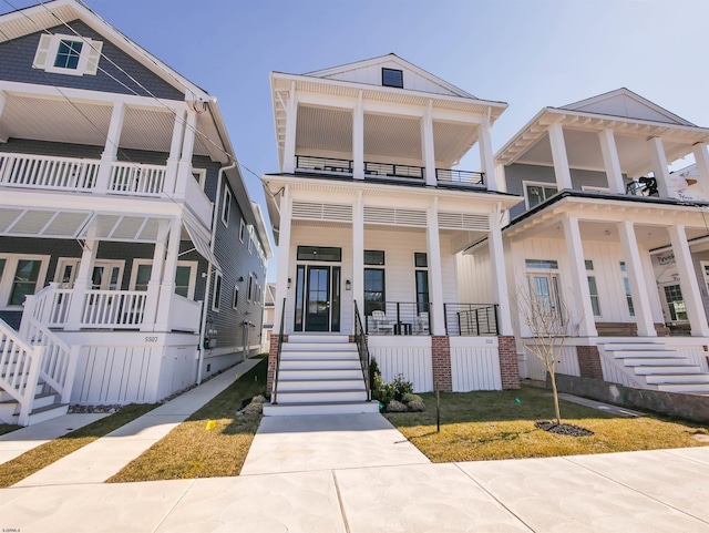 view of front of home with covered porch, stairs, and a balcony