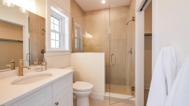 bathroom featuring vanity, toilet, and a stall shower