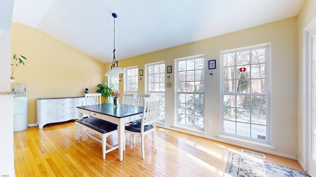 dining room with vaulted ceiling, light wood-style floors, visible vents, and a healthy amount of sunlight