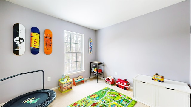 game room featuring light carpet and baseboards