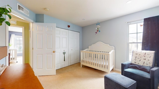 bedroom with visible vents, carpet, and a closet