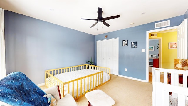 carpeted bedroom featuring a closet, visible vents, a ceiling fan, and baseboards