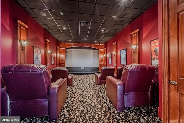 cinema room featuring visible vents, carpet flooring, and a paneled ceiling