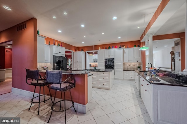 kitchen featuring visible vents, a peninsula, light tile patterned flooring, and black fridge