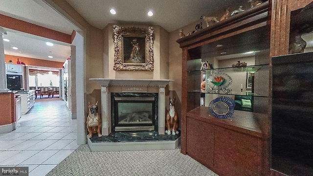 interior space featuring tile patterned floors, a glass covered fireplace, and recessed lighting