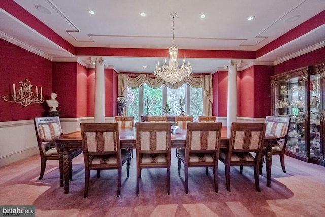 dining room with a raised ceiling, carpet flooring, crown molding, and wainscoting