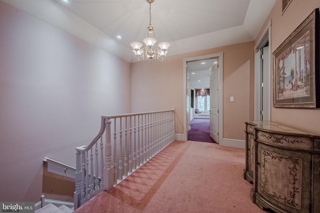 hallway featuring an upstairs landing, a chandelier, carpet, and baseboards