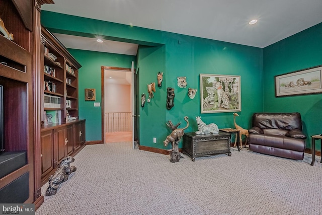 living area featuring baseboards and carpet