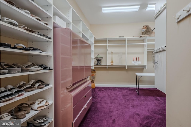 walk in closet featuring dark carpet