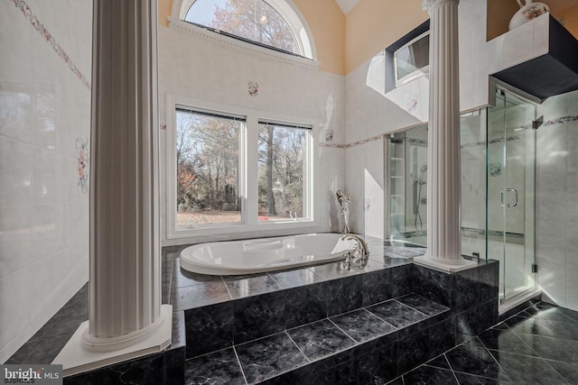 full bathroom with a bath, a stall shower, and decorative columns