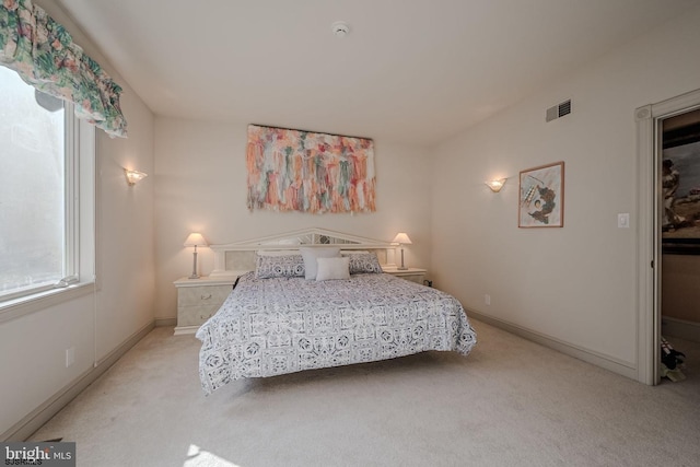 bedroom featuring light carpet, visible vents, and baseboards