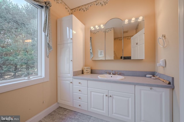 bathroom with tile patterned flooring, vanity, and baseboards