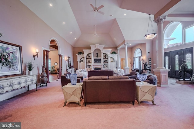 living area featuring light carpet, high vaulted ceiling, a ceiling fan, and decorative columns