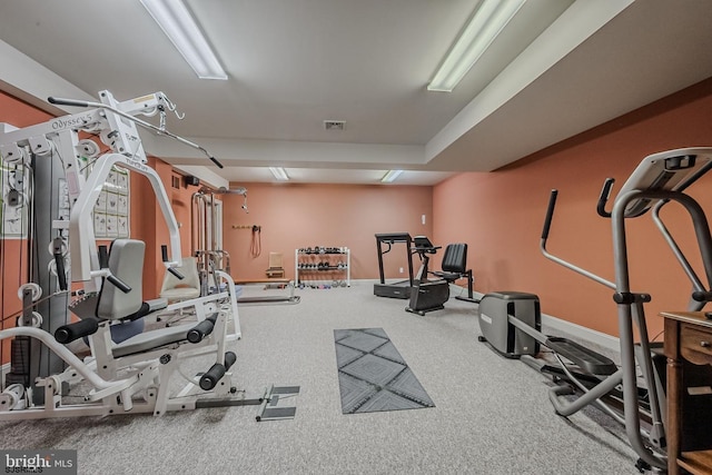 exercise area featuring baseboards and carpet floors