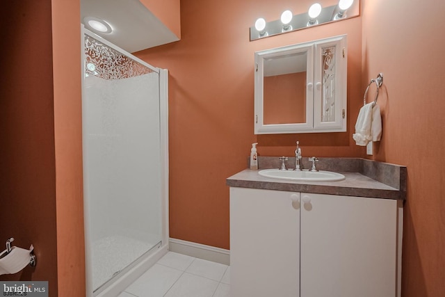 full bath featuring baseboards, vanity, a shower stall, and tile patterned flooring