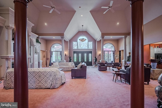 living area featuring carpet flooring, high vaulted ceiling, ceiling fan, and decorative columns