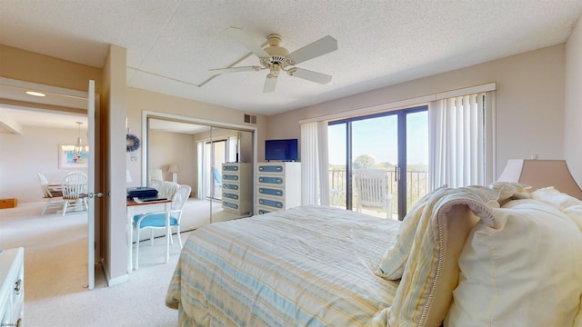 carpeted bedroom featuring visible vents, a closet, a textured ceiling, access to outside, and ceiling fan with notable chandelier