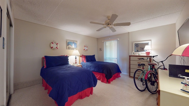 bedroom featuring baseboards, carpet floors, a textured ceiling, and a ceiling fan