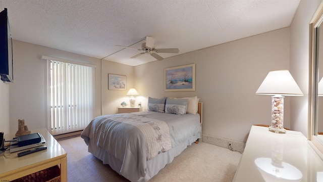 carpeted bedroom featuring a textured ceiling and ceiling fan