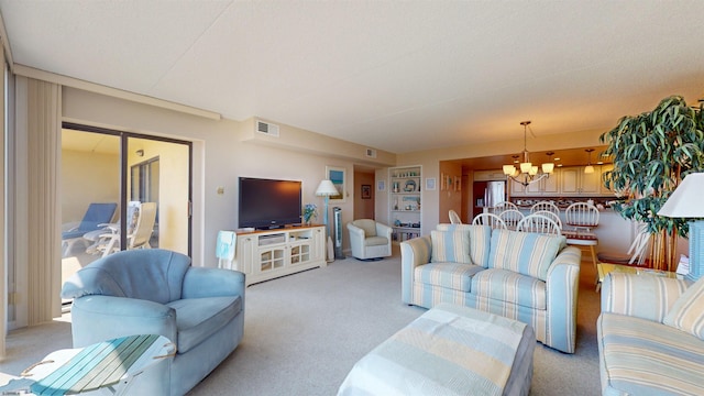 living area featuring a chandelier, visible vents, and light colored carpet