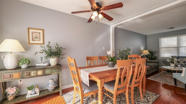 dining space with ceiling fan, visible vents, baseboards, and wood finished floors