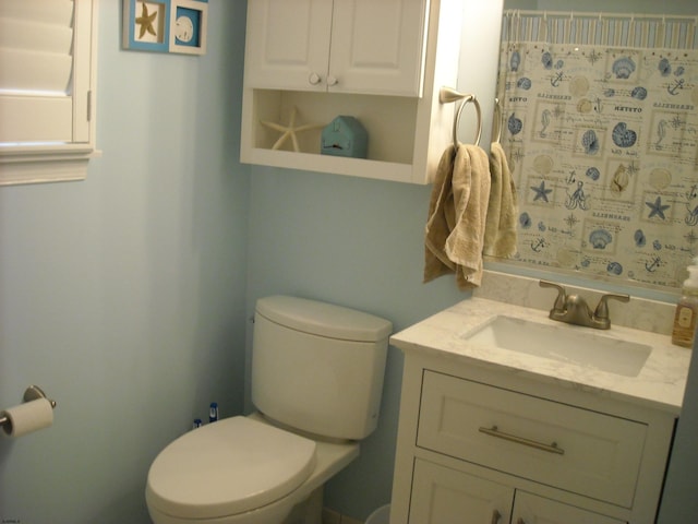 full bathroom with vanity, curtained shower, and toilet