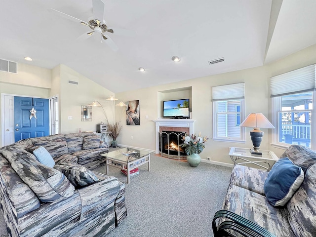 carpeted living area featuring vaulted ceiling, baseboards, visible vents, and a lit fireplace