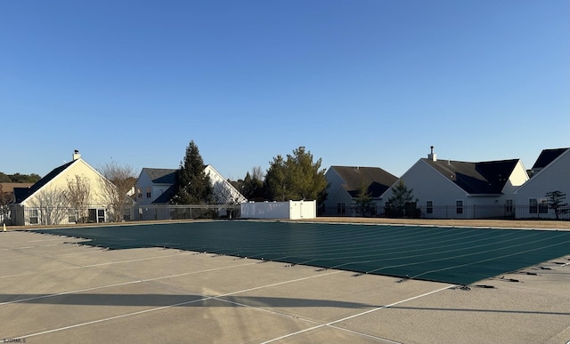 community pool with a patio area and fence