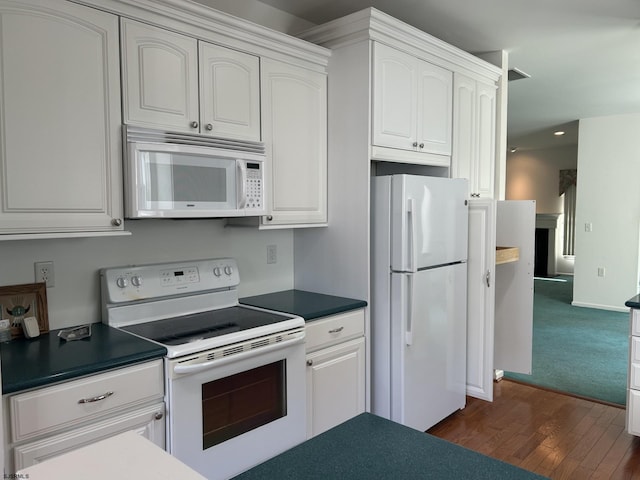 kitchen with dark countertops, white appliances, white cabinetry, and dark wood-type flooring