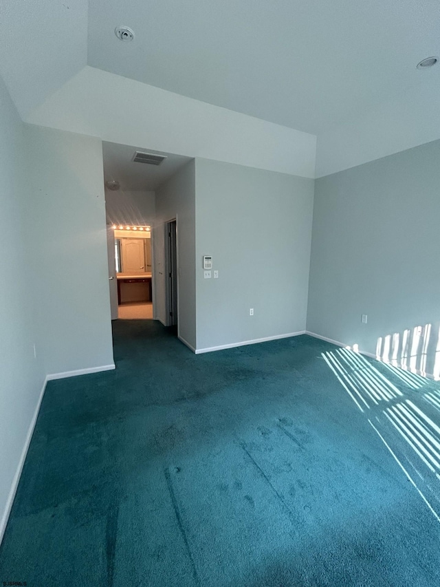 unfurnished room with visible vents, baseboards, and dark carpet