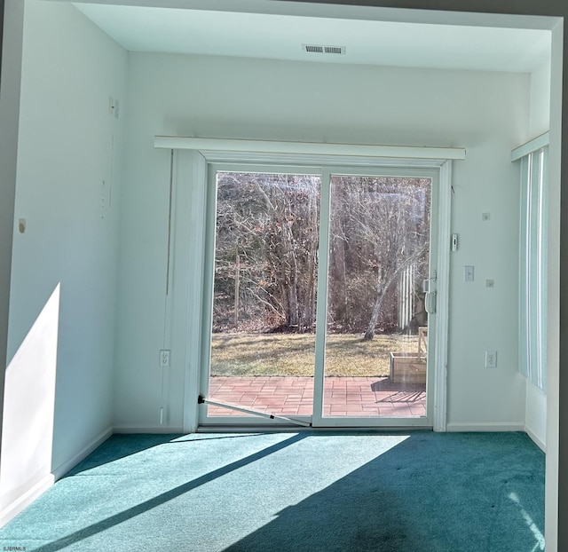 doorway to outside featuring baseboards, visible vents, and carpet floors