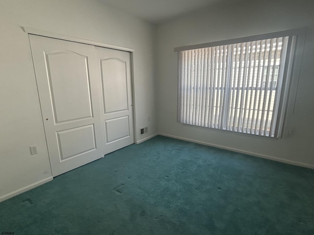 unfurnished bedroom featuring a closet, carpet flooring, baseboards, and visible vents