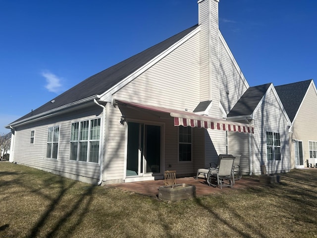 back of property featuring a patio area, a lawn, and a chimney