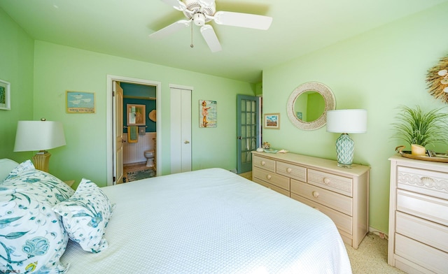 bedroom with light colored carpet, connected bathroom, and a ceiling fan