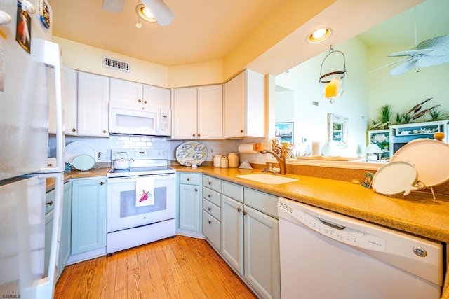 kitchen with ceiling fan, white appliances, light wood-style flooring, and a sink