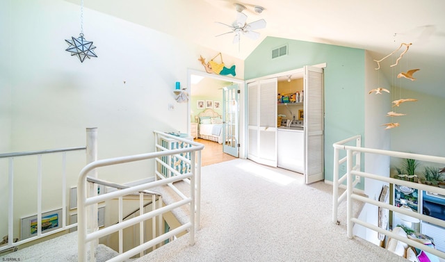 hall featuring independent washer and dryer, vaulted ceiling, visible vents, and carpet floors